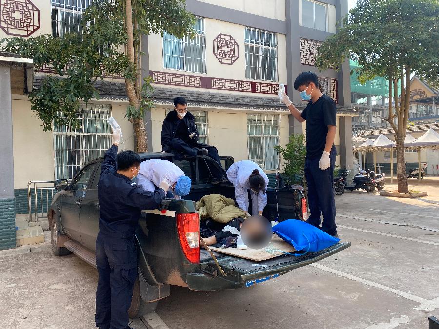 图为移民管理警察将男子送至卫生院